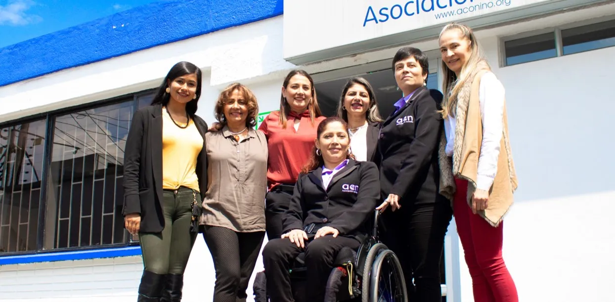 Integrantes del equipo de Aconiño junto a una persona usuaria de silla de ruedas en la sede actual