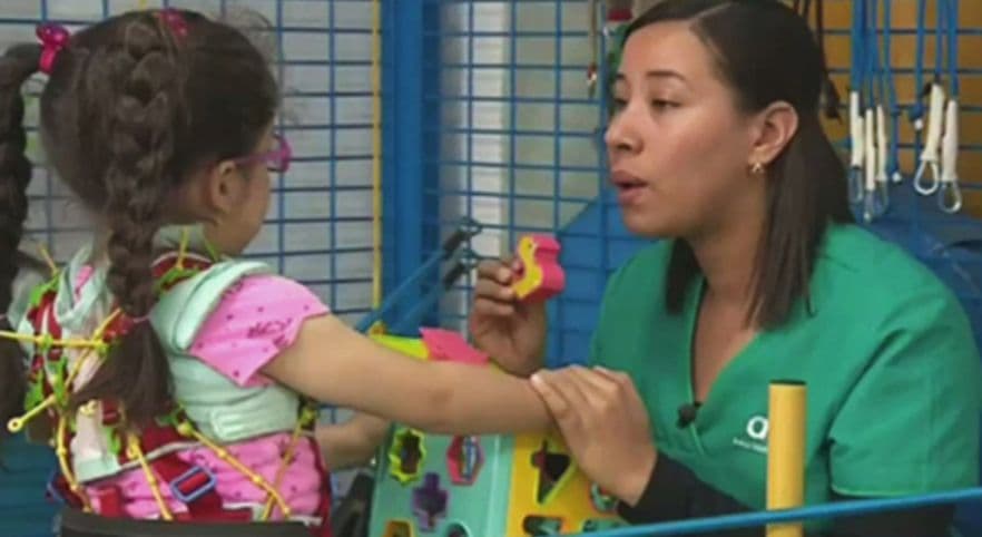Terapeuta ayudando a niña
